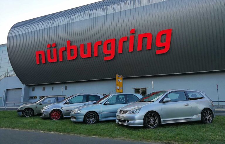 Hot hatches parked infront of the sign at the Nurburgring